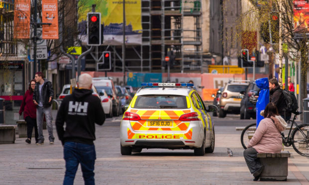 Police drive along the pedestrian High Street, Perth during the lockdown.