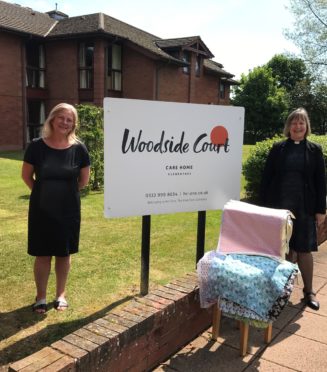 Nicola Proctor, manager of Woodside Court Care Home receives 40 handmade laundry bags from Rev Eileen Miller.