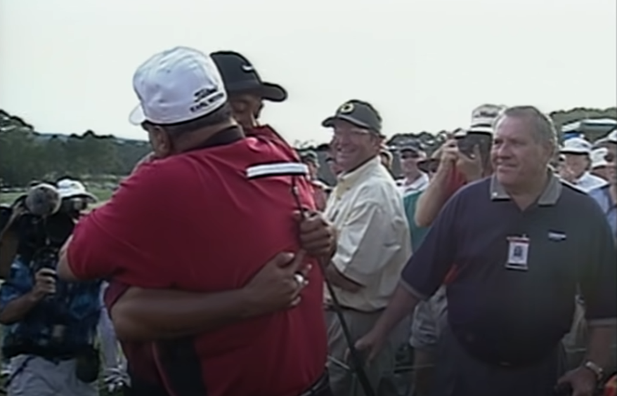 He hugs father Earl Woods, who passed away five years later