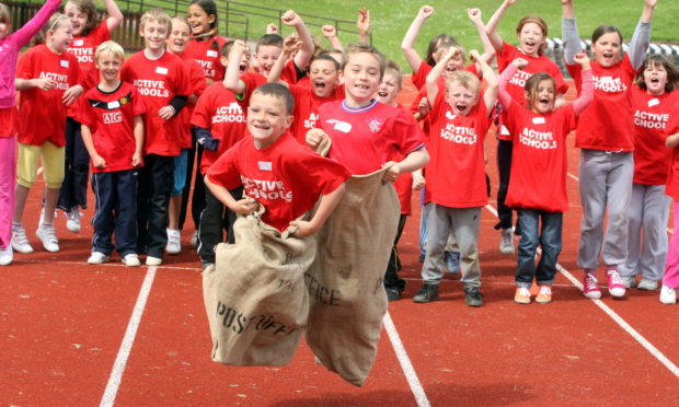 Primary School mini Highland games at Caird Park, Dundee - Baldragon feeder schools of Downfield, Sidlawview and Ardler PS  with Michael Gillan of Ardler Primary School and Mark Bertinshaw of Downfield during a sack race