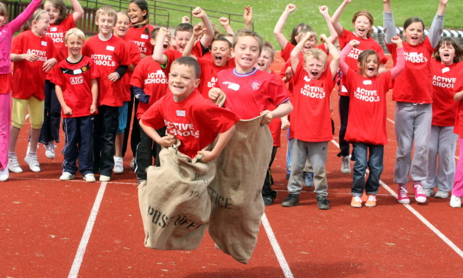 Primary School mini Highland games at Caird Park, Dundee - Baldragon feeder schools of Downfield, Sidlawview and Ardler PS  with Michael Gillan of Ardler Primary School and Mark Bertinshaw of Downfield during a sack race