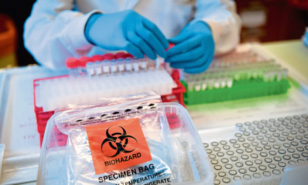 Lab technicians handle suspected Covid-19 samples as they carry out a diagnostic test for coronavirus.