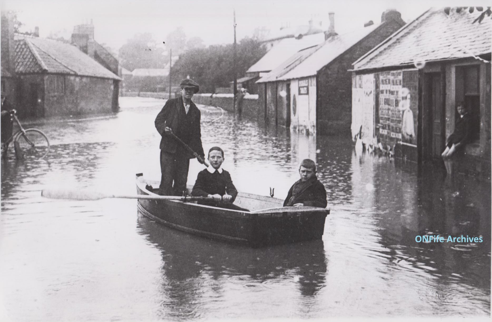 Young boys in a boat after Cupar floods in 1916.