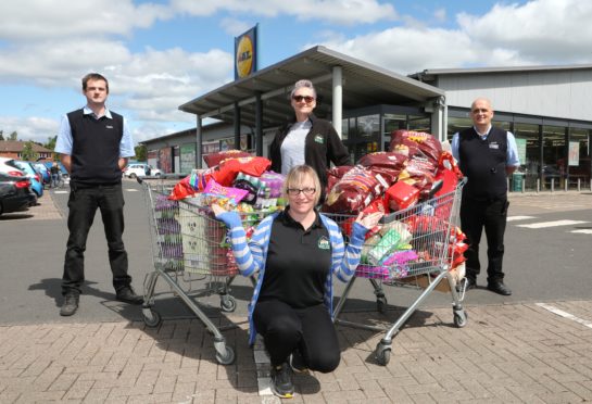 Left to right: Gordon Thompson, store Deputy Manager; Debbie Hay of CATH; Pam Lindsay of CATH (kneeling); and Ken McNamee, Shift Manager. Picture: Gareth Jennings.