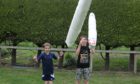 Brothers Marshall Cochrane, 7, and Alex, 10, practice tossing their kitchen roll cabers in preparation  for the virtual games.