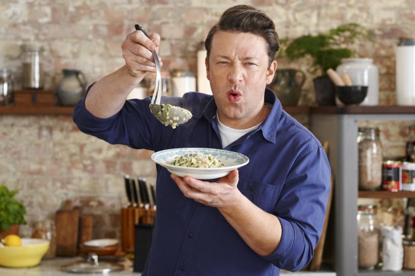 Photo shows the celebrity chef Jamie Oiliver pulling a face next to a plate of pasta.