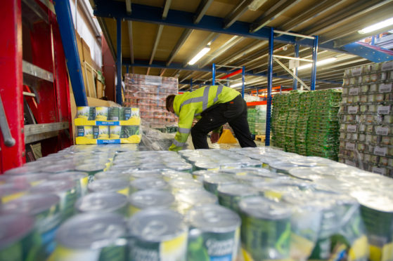 Volunteers prepare pallets of food for distribution.