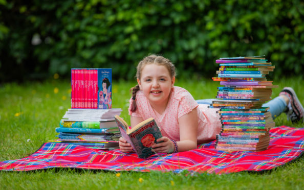 Kaylie Laing, 8, with some of the books she has powered through during lockdown.