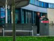 A person stubbing out a cigarette on a bin that has a no-smoking sign at the Main Entrance, Victoria Hospital, Kirkcaldy.