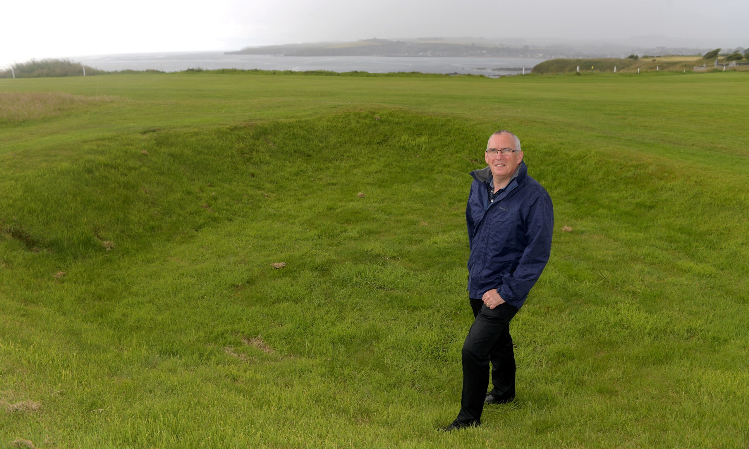 Club manager Stewart Kerr standing in Hitler's Bunker, the remnants of a crater left by a World War Two bomb between the first and second fairways of the course.