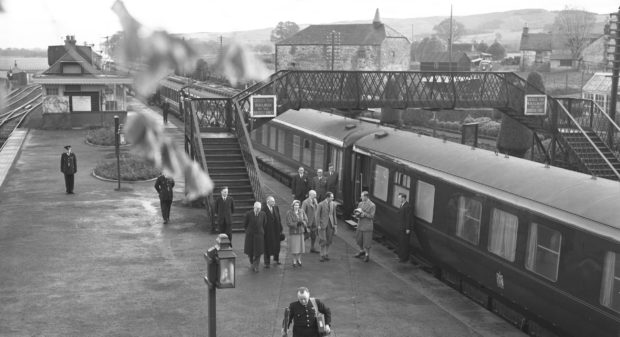 The Queen and Duke of Edinburgh exit a train at Alyth Station in October 1957.