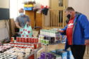 Ross Clark - Community Volunteer serving Christopher McIntosh, at the Fintry Food Larder, in Fintry Parish Church, Dundee.