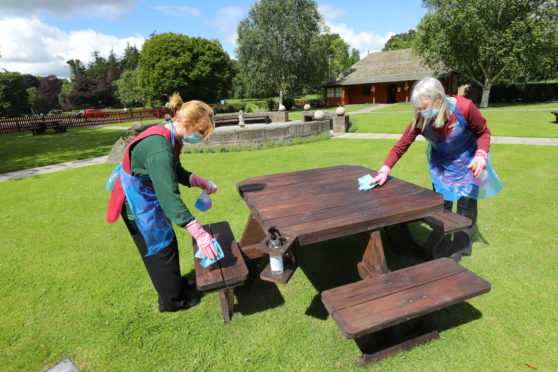 Cleaners Jamie Sheilds, left, and Wendy Greenhill wiping down one of the picnic benches at Glamis Castle.