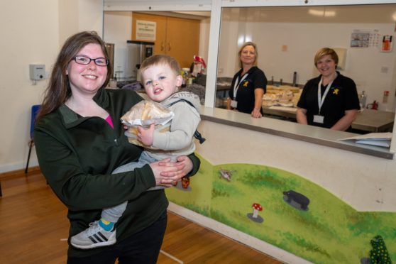 Jillian Cartmel, who is accompanied by her one-year-old son Lucas, collecting lunch from Zoe Taylor and Kerry Jones.