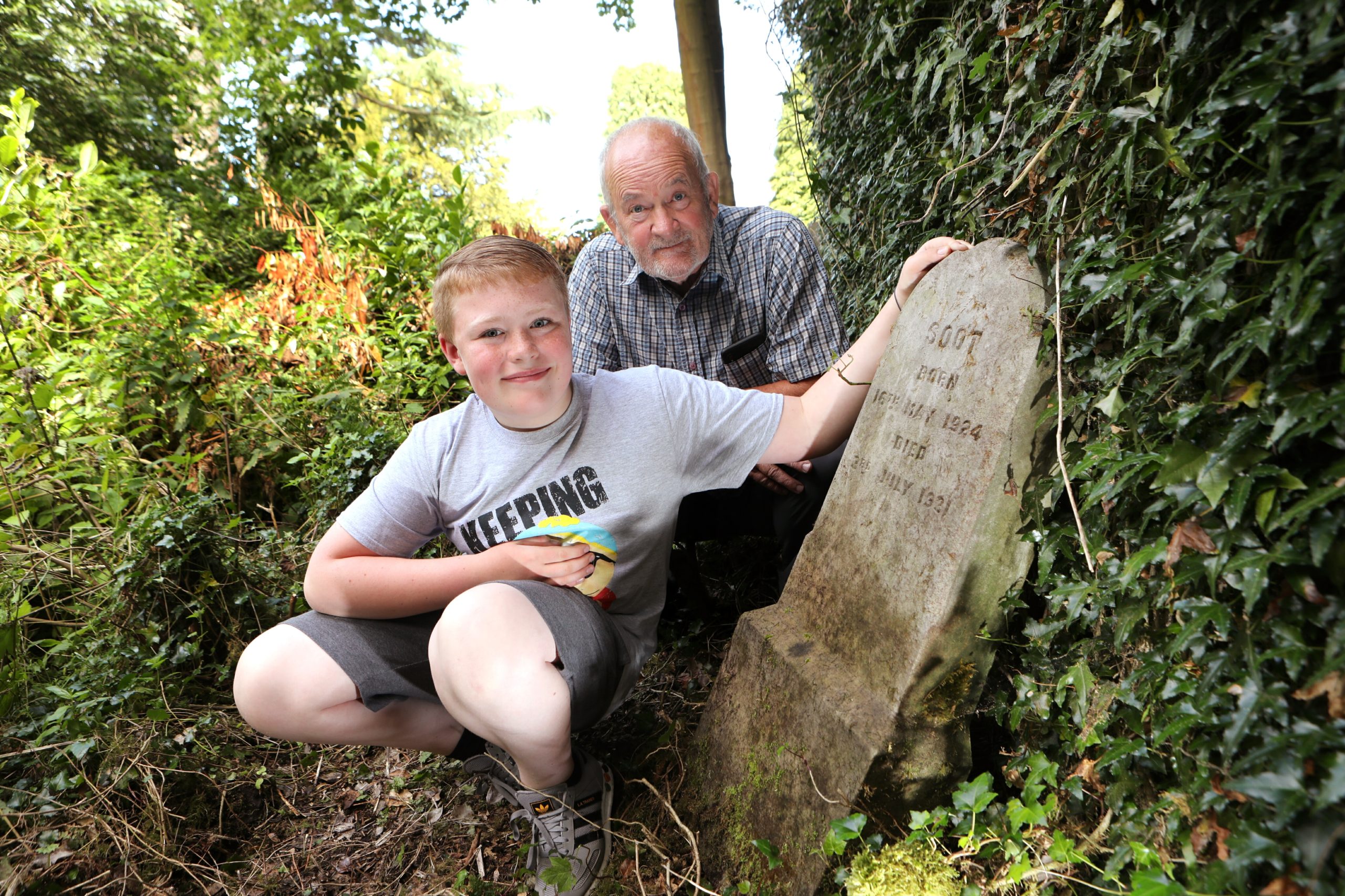 Frank McCafferty with grandson Jed at the pet cemetery that they discovered.