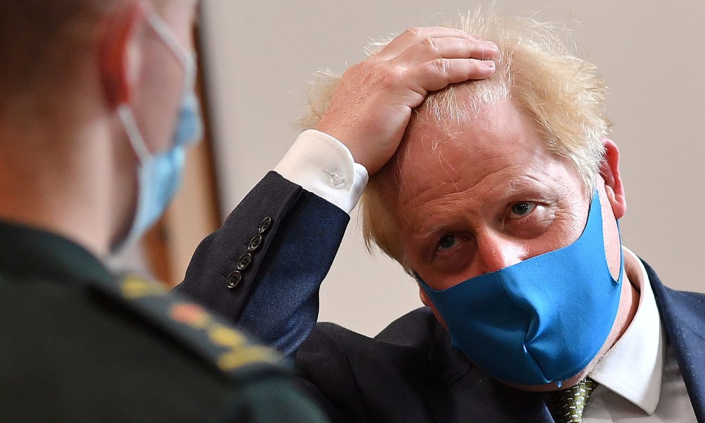 Prime Minister Boris Johnson, wearing a face mask, talks with a paramedic during a visit to the headquarters of the London Ambulance Service NHS Trust.