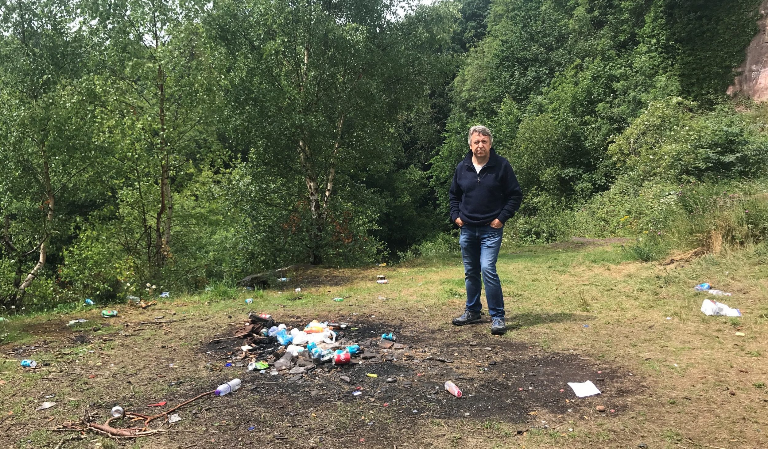 Councillor Angus Forbes next to some of the discarded rubbish at Kingoodie.