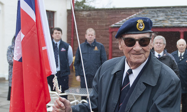 Captain Davidson raises the Red Ensign at a ceremony in Arbroath in 2018.