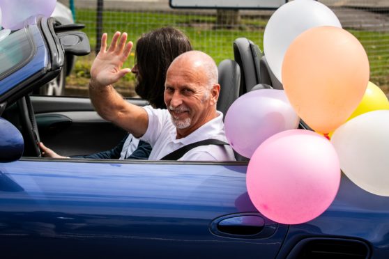 Mr Mitchell in an open top Porsche.