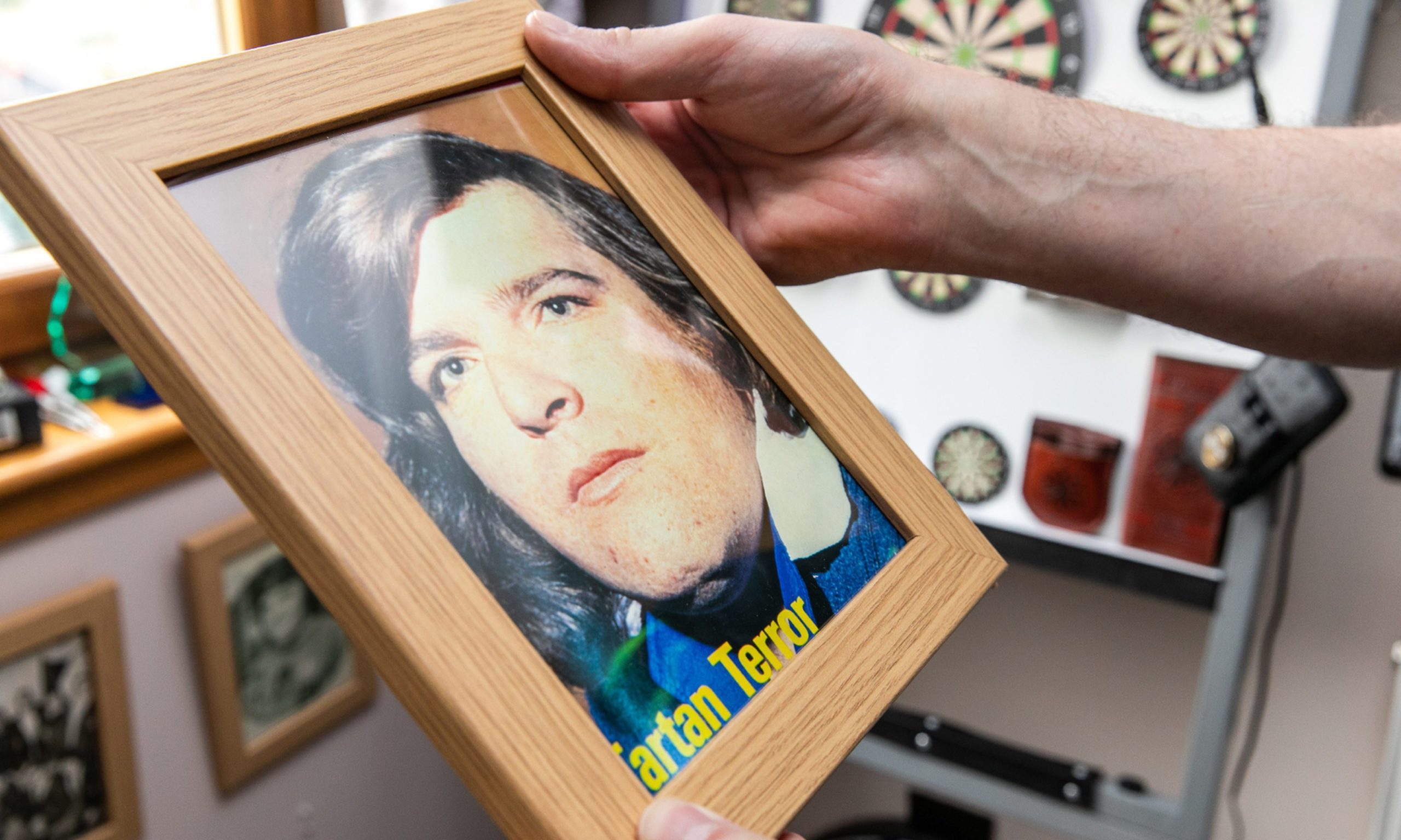 Wullie Burness holds a framed picture of his friend Jocky Wilson.