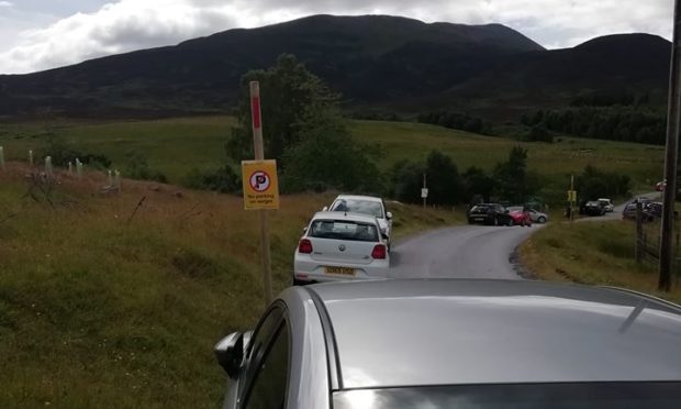 Cars abandoned beside no parking sign near Braes of Foss car park