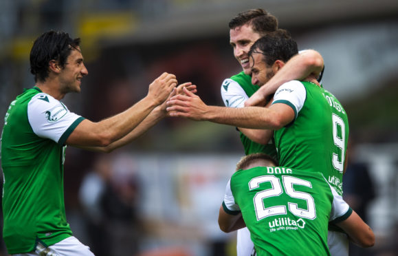 Christian Doidge (No 9) is mobbed after netting the winner for the Hibees.