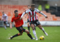 United kid Kerr Smith challenges Sheffield United star Callum Robinson in wet conditions.