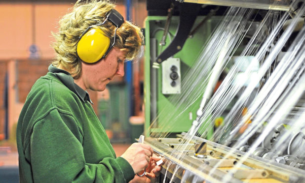 A textile worker at a  loom at the Scott and Fyfe facility in Fife. Picture: Kim Cessford