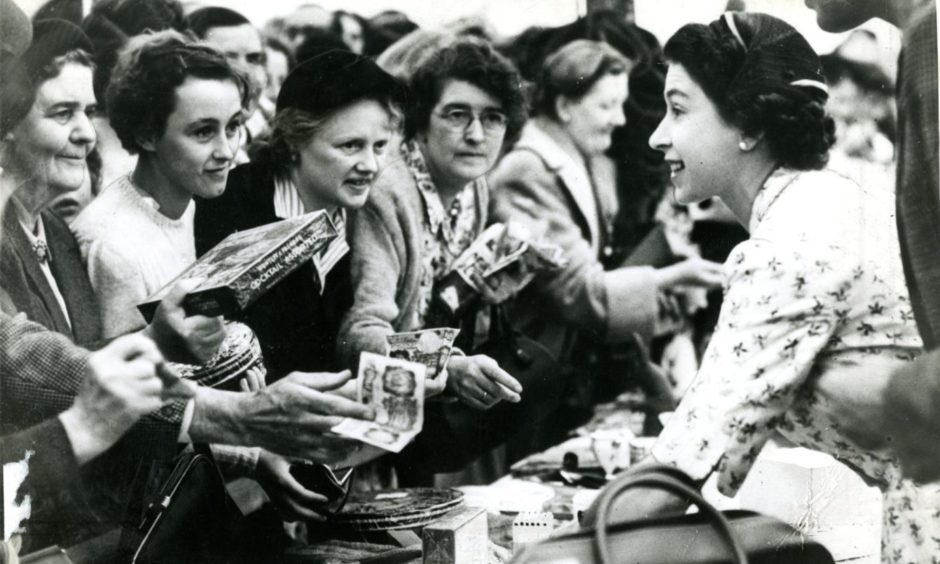 Queen Elizabeth hard at work at the memorable sale of work on Royal Deeside, 65 years ago.