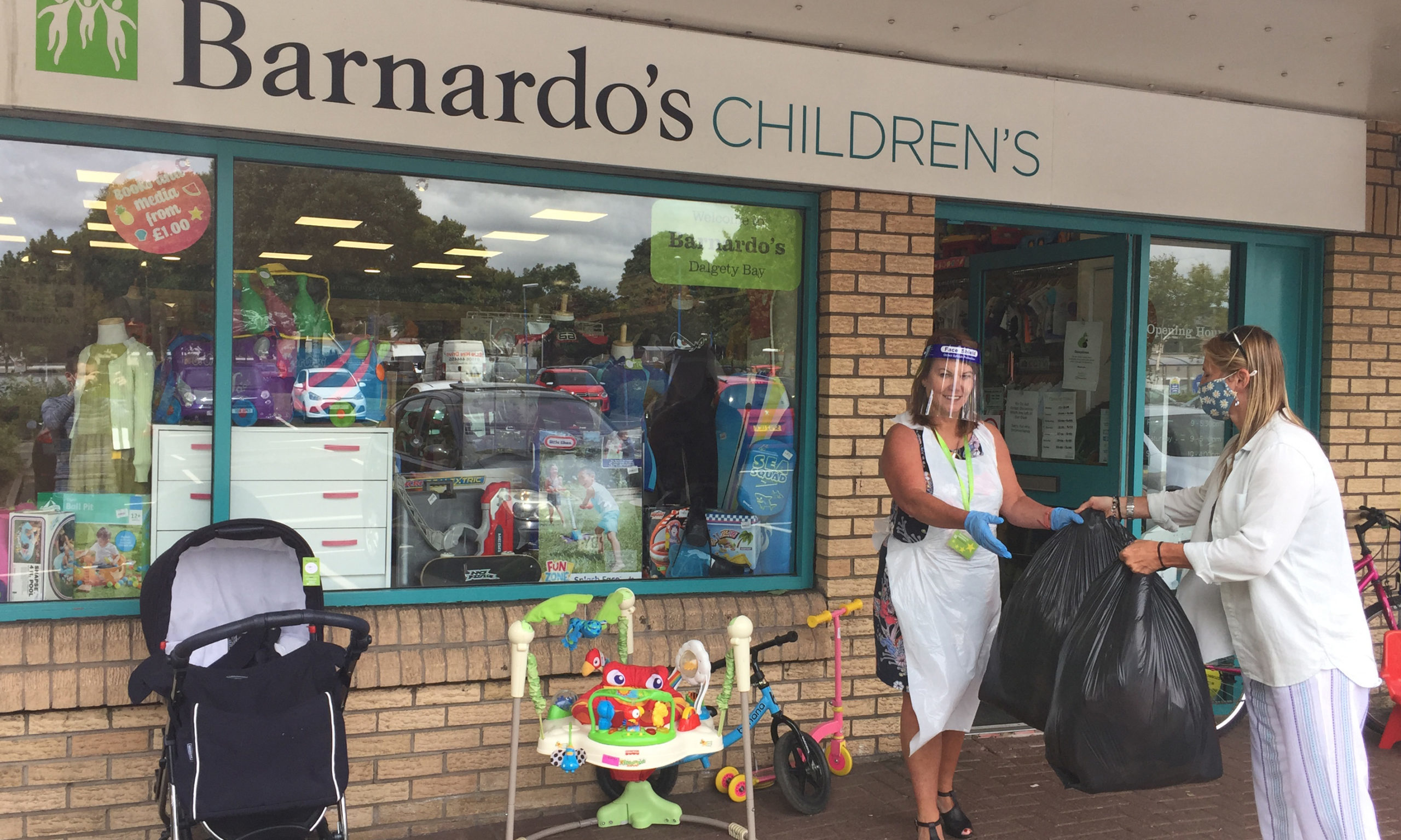 Barnardo's Dalgety Bay manager Theresa Allan accepts a donation from a customer.