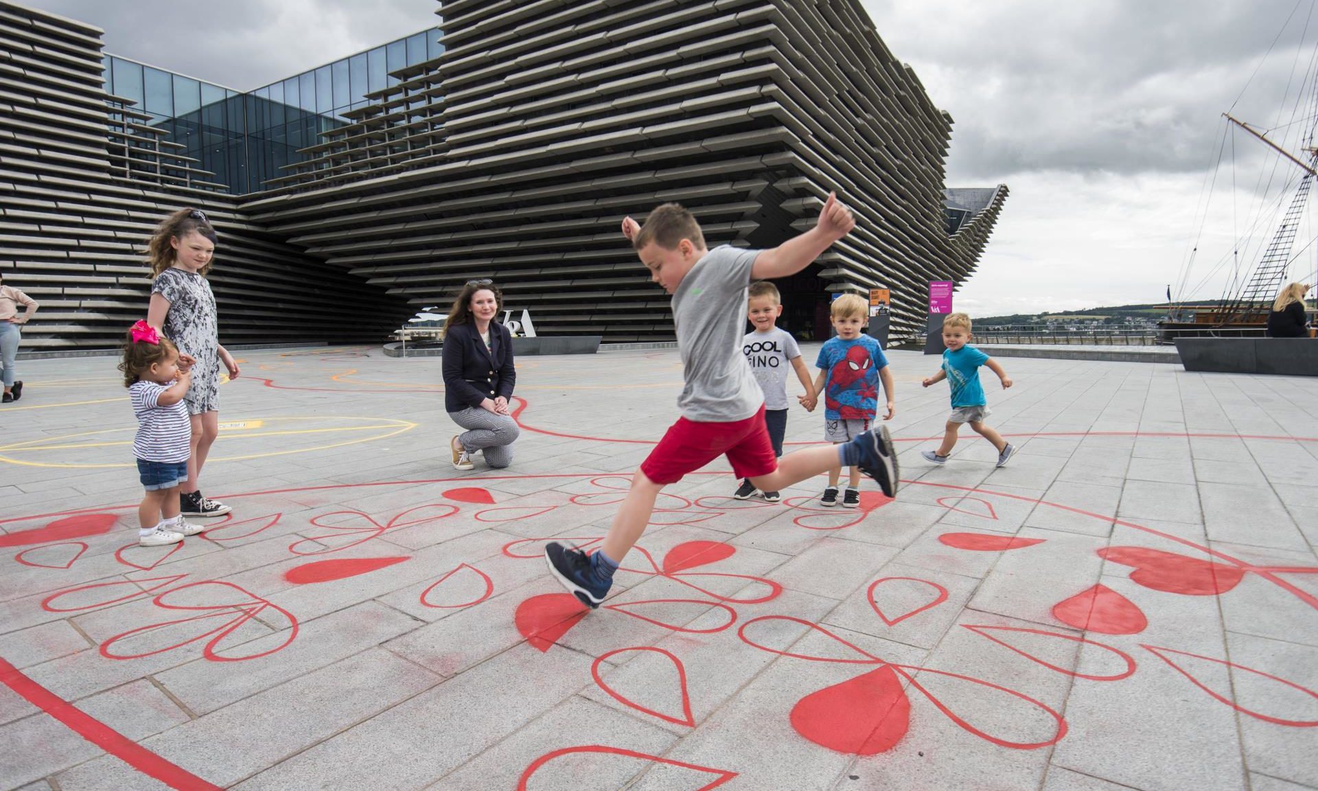 Jack Coulthard, 8, plays on the new interactive playground with Kirsty Hassard, curator at V&A Dundee.