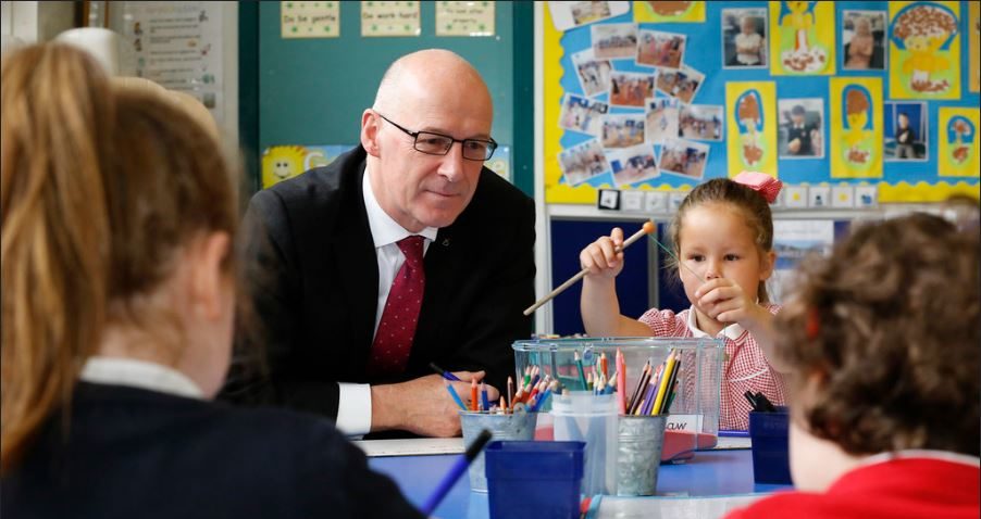 Education Secretary John Swinney helps youngsters learn before the coronavirus pandemic closed schools.