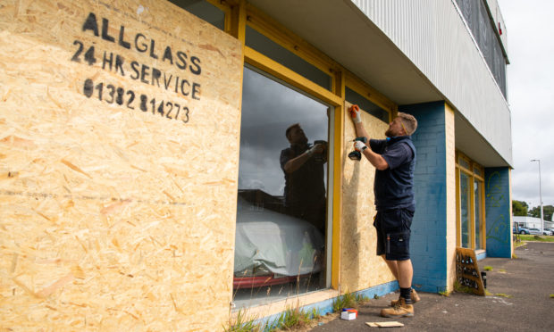 Workers repair the broken windows at the Carmeleon Preparation Centre.
