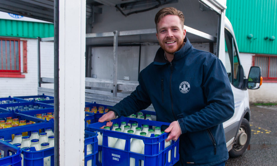 Kelvin Kerr Jnr with a crate of glass milk bottles.