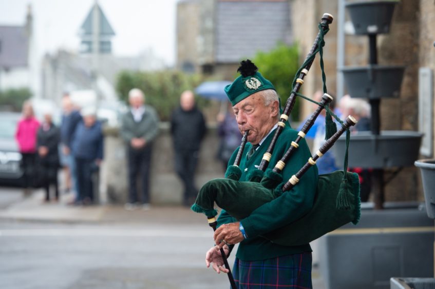 Beadle Piper Patrick Glendinning pipes outside Burghead's Church of Scotland in tribute to the men who died in the Stonehaven train crash.
