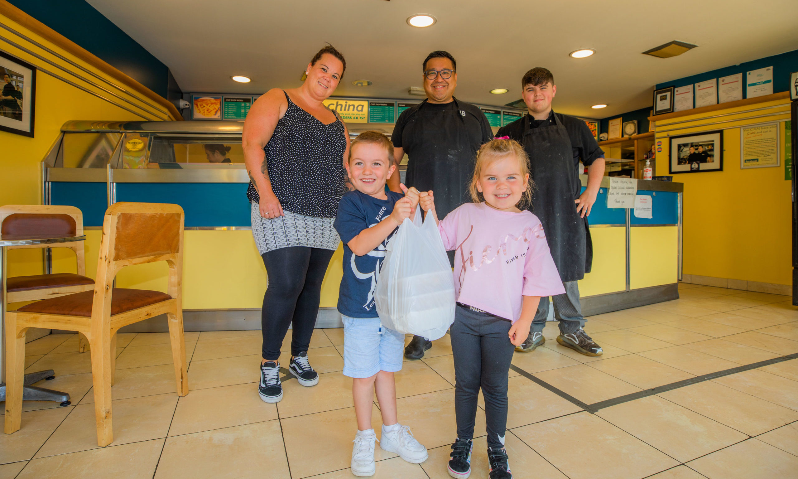 Mason and Olivia Harvey (aged 4) alongside mum Jo Harvey, Pete Chan and staff member
Ciaran Cushnie. Jo and children are delivering the food to a friend that she nominated