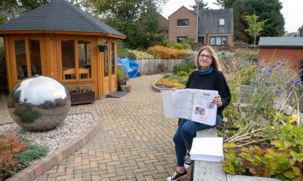 Kirrie Connections activities co-ordinator Gail Robertson at the Kirriemuir Community Garden with some of the newsletters. Pic: Paul Reid
