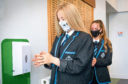 Scottish school children wearing mask and using hand sanitiser after first returning to classrooms in 2020.