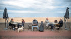 People drink coffee on the promenade at Portobello Beach, Edinburgh.