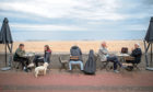People drink coffee on the promenade at Portobello Beach, Edinburgh.