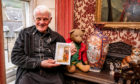 Retired detective and Violin Shop owner Bob Beveridge with copies of his new book 'An Extraordinary Autobiography'