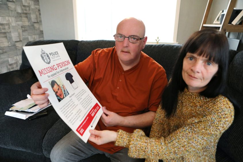 Allan's parents Marie Degan and Allan Bryant Snr holding a missing person poster for their son Allan Bryant Jnr