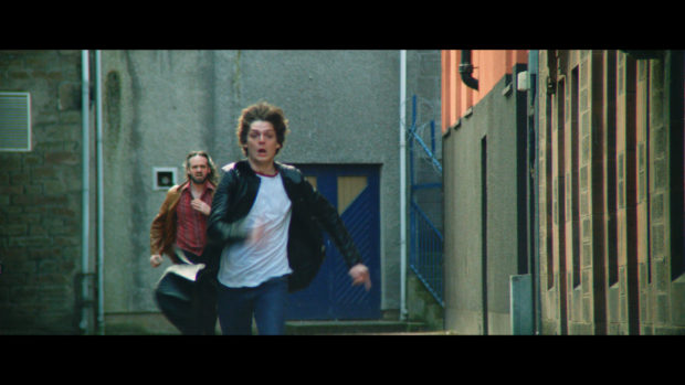 Actor Conor Berry, who plays rock promoter Dave McLean, in a chase scene from Schemers.