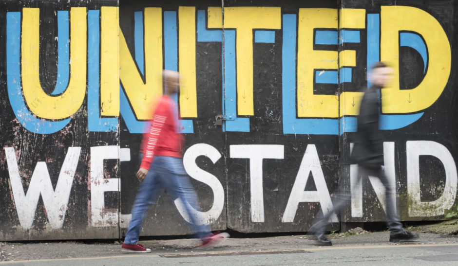 A general view of people walking past graffiti in Leeds.