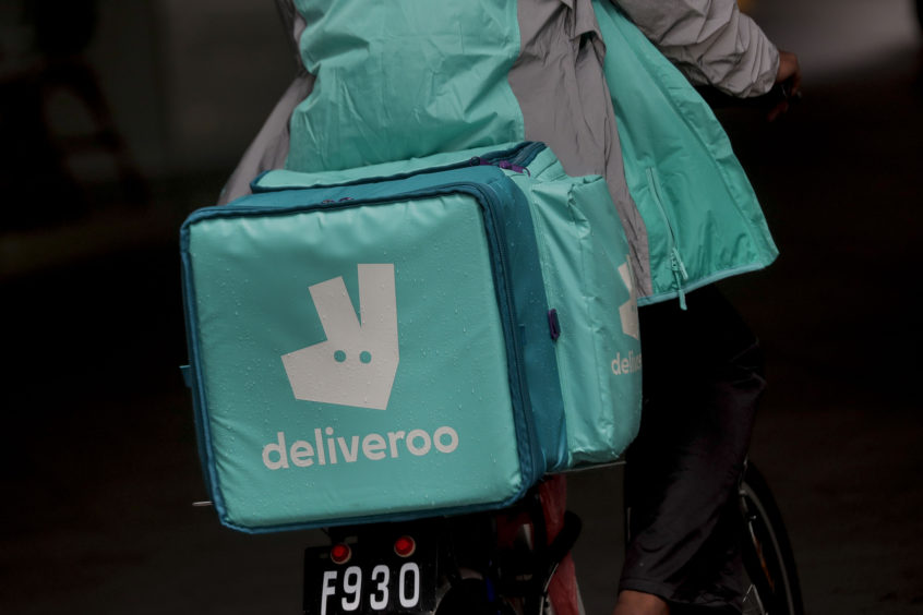 Photo shows a cyclist with a Deliveroo satchel on his back.
