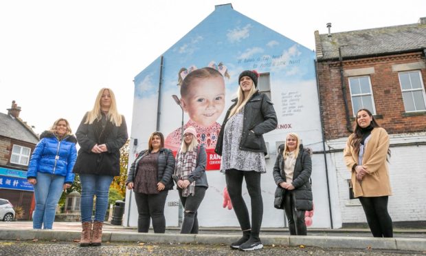 Arlene Falconer, Donna Forrester, Annilie Muller, Amy Jeffrey, Danielle Falconer, Aisha Ferguson, and Carlin Robertson next to the mural in Townhill.