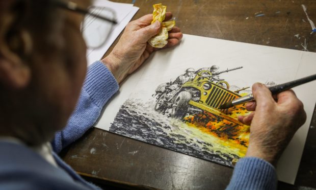 Illustrator Ian Kennedy in his studio working on a Commando image.