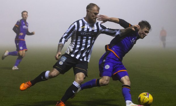 Richard Tait and Dundee United left-back Jamie Robson chase down the ball at a foggy St Mirren Park.