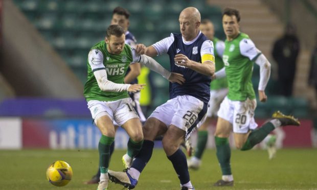 Wearing the captain‘s armband, Dundee‘s Charlie Adam tackles former Dee Martin Boyle at Easter Road.