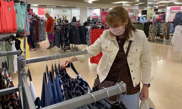 A woman shops in a near deserted Debenhams store